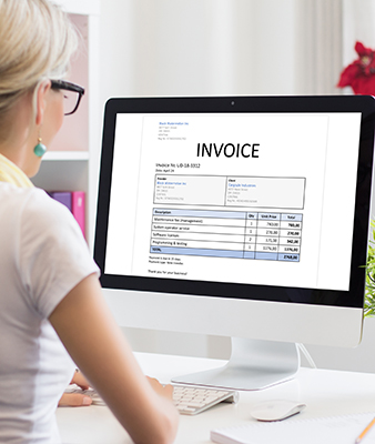 Woman in office with sample invoice document on computer